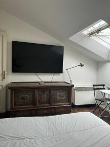 1 dormitorio con TV de pantalla plana en la pared en Heart of Parma - Air Conditioning con posto auto prenotabile, en Parma
