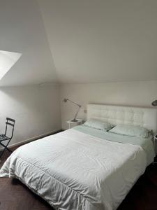 Dormitorio blanco con cama blanca grande y lámpara en Heart of Parma - Air Conditioning con posto auto prenotabile, en Parma