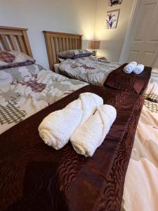 two white towels are sitting on a bed at Max's Woodland Lodge in Bridlington