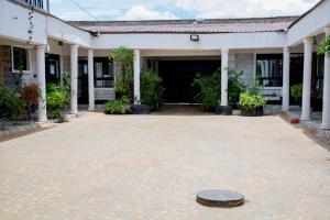 an empty courtyard of a building with a clock in the middle at Shanny's apartment in Eldoret