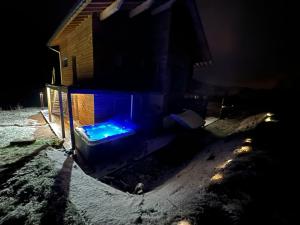 una hoguera azul en la nieve por la noche en Chalet de l'ancienne école, Jacuzzi privé, en Gérardmer