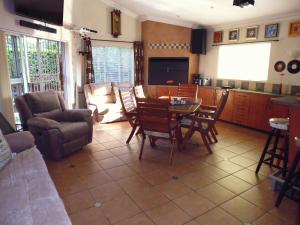 a living room with a table and chairs and a kitchen at Dobbs Lodge in Centurion