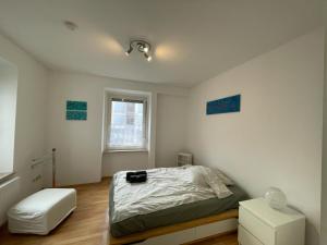 a white bedroom with a bed and a window at 32m2 - gemütliche Wohnung in zentraler Lage in Hagen