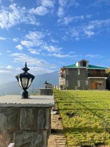 una casa con un lampione di fronte a un campo di Charmed Chateau a Shimla