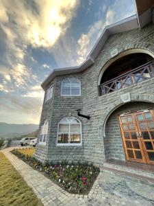uma casa com um edifício de pedra com uma porta em Charmed Chateau em Shimla