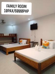 a room with two beds and a flat screen tv at Lang2 place in Coron