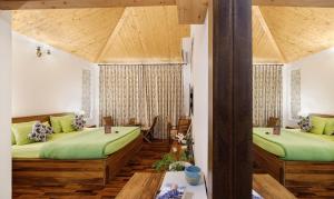duas camas num quarto com lençóis verdes em Charmed Chateau em Shimla