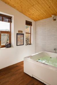 uma grande banheira branca num quarto com uma janela em Charmed Chateau em Shimla