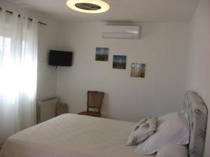 una camera da letto con un letto e una TV a parete di Chambre d'hôtes à Usclas d'Hérault a Usclas-lʼHérault