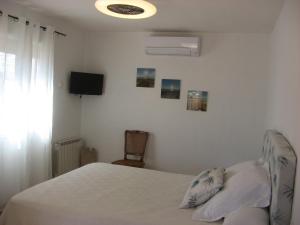 a bedroom with a bed and a tv on the wall at Chambre d'hôtes à Usclas d'Hérault in Usclas-lʼHérault