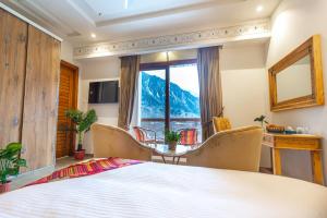 a bedroom with a large bed and a table and chairs at Zen Luxus Royal Serene Resort in Kalām