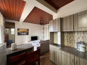 a kitchen with wooden cabinets and a living room at NINHO APPARTEMENT in Rubavu