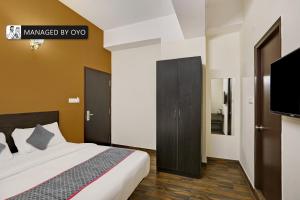 sypialnia z łóżkiem i telewizorem z płaskim ekranem w obiekcie Super Collection O Singasandra Hosa Road w mieście Bengaluru