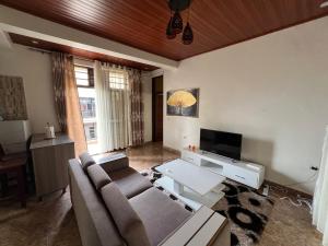 a living room with a couch and a tv at NINHO APPARTEMENT in Rubavu