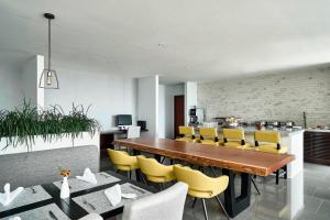 a dining room with a wooden table and yellow chairs at Marriott Santa Cruz de la Sierra Hotel in Santa Cruz de la Sierra