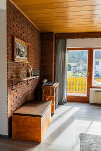 a living room with a brick wall and a bench at Ferienwohnung Am Rhaunelbach in Rhaunen