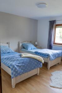 1 dormitorio con 2 camas y ventana en Ferienwohnung Am Rhaunelbach, en Rhaunen
