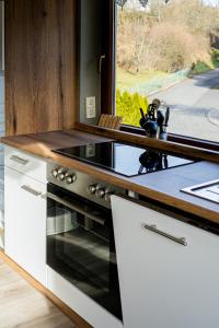 a kitchen with a stove top oven next to a window at Ferienwohnung Am Rhaunelbach in Rhaunen