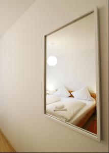 a mirror reflecting a bed with white sheets and pillows at 2 Zimmer Appartement mit Pool im Haus in Schluchsee