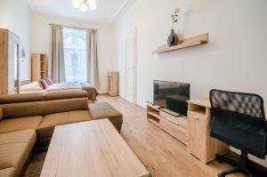 uma sala de estar com um sofá e uma televisão em Historic Centre Apartments V em Praga