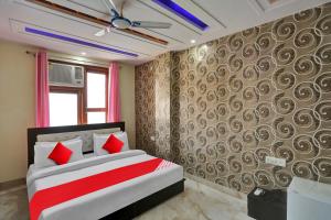 a bedroom with a bed with red pillows at OYO Flagship Hotel Metro Height's near Nangloi Railway metro station in New Delhi