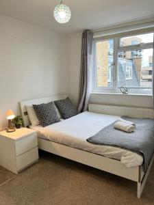 a bedroom with a large bed with a window at Cozy Room in whitechapel! Central London in London