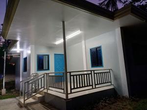 Edificio blanco con balcón y ventanas azules en 2br Hilltop Haven w/ Wi-Fi, en Davao City
