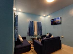 - un salon avec deux chaises et une télévision à écran plat dans l'établissement 2br Hilltop Haven w/ Wi-Fi, à Davao