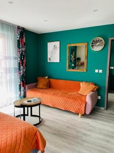 a bedroom with an orange bed and a green wall at Apartament U Bartusia in Zakopane