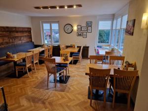 ein Restaurant mit Holztischen und -stühlen und einer Uhr in der Unterkunft Pension Sonnenheim Rooms&Apartments in Gmünd in Kärnten