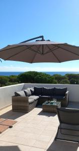 a patio with a couch and an umbrella at La Casa dei Pesci in Budoni