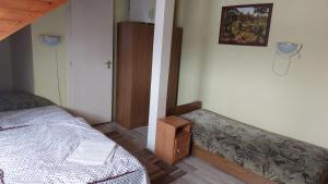 a bedroom with a bed and a small cabinet at Napsugár Panzió in Vác