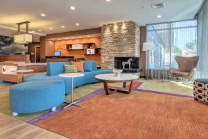 Una sala de estar con un sofá azul y una chimenea. en Fairfield Inn & Suites by Marriott Greenville, en Greenville