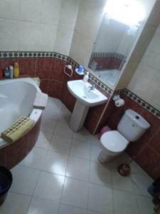 y baño con bañera, aseo y lavamanos. en Appartement agadir centre, en Agadir