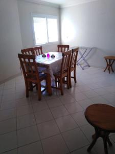 een eetkamer met een tafel en stoelen en een raam bij Appartement agadir centre in Agadir