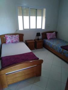 een slaapkamer met 2 bedden en een raam bij Appartement agadir centre in Agadir