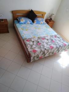 een bed met een dekbed en kussens in een slaapkamer bij Appartement agadir centre in Agadir