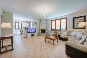 salon z kanapą i telewizorem w obiekcie Villa La Dolce Vita - Happy Rentals w mieście Leggiuno
