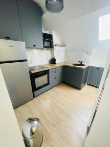 a kitchen with stainless steel appliances and a wooden floor at Studio Parc des Princes - Porte dauphine - 2 Pers in Boulogne-Billancourt
