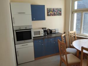 a small kitchen with a table and a microwave at Stadtblick 2 Monteuerglück in Eisenberg