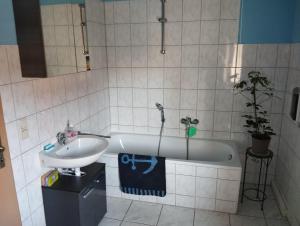 a bathroom with a sink and a bath tub at Stadtblick 2 Monteuerglück in Eisenberg +21 photos