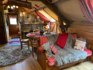 a living room with a couch and a table at Gîte "Le Refuge" Dans un Domaine de 7ha Au Calme in Vimoutiers