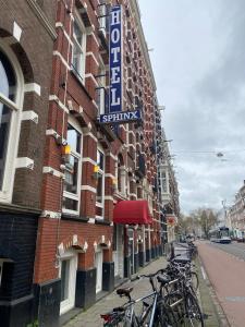 un grupo de bicicletas estacionadas fuera de un edificio en Hotel Sphinx, en Ámsterdam