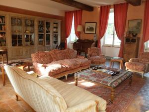 ein Wohnzimmer mit Sofa, Stühlen und einem Tisch in der Unterkunft Château Seguier - Loire Valley and vineyards in Brinon-sur-Sauldre