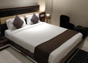En eller flere senge i et værelse på Hotel Aradhana Auberge