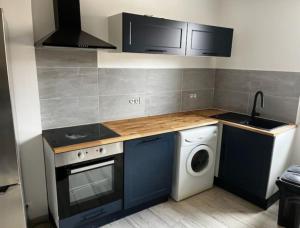 een keuken met een wasmachine en een wasmachine bij centre de Thuir appart cosy in Thuir