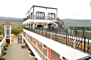 - un bâtiment avec un balcon avec des vaches dans l'établissement Lakewood city Resort, à Narok