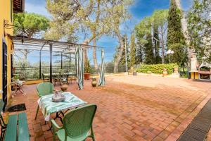 a patio with a table and chairs on a brick patio at Villa Paola Private Pool Gym in Chianti - Happy Rentals in Montespertoli