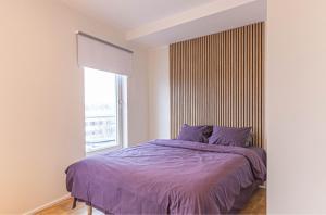 a bedroom with a bed with purple sheets and a window at Aida 7 Apartment in Pärnu