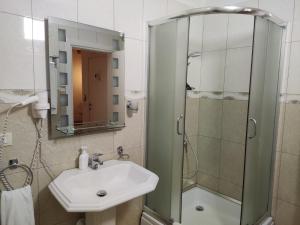 a bathroom with a sink and a shower at Hotel & Restaurant White City in Berat